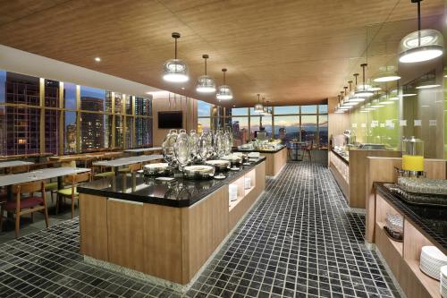 a restaurant with a bar with a view of the city at ibis Kuala Lumpur City Centre in Kuala Lumpur