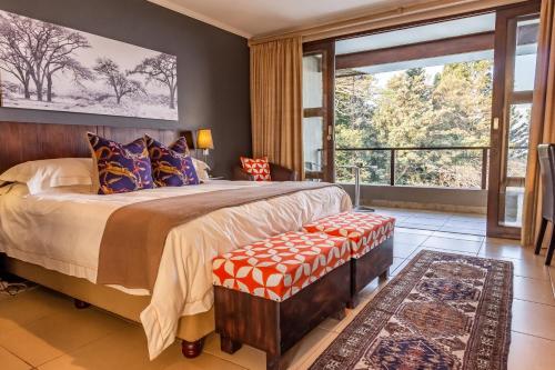 a bedroom with a large bed and a large window at One On Hely in Mtunzini