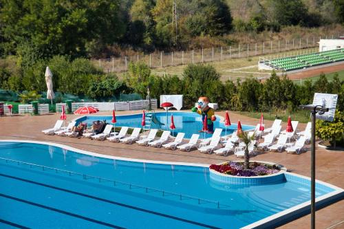 a swimming pool with lounge chairs and a swimming pool at Balneo and SPA Complex MINERAL YAGODA in Yagoda