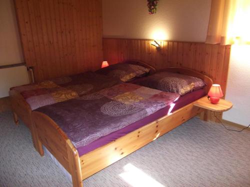 a bedroom with a wooden bed with two lamps at Ferienwohnung Erzgebirge - Pobershau - mit schönem Ausblick, ruhige, beste Lage in Pobershau
