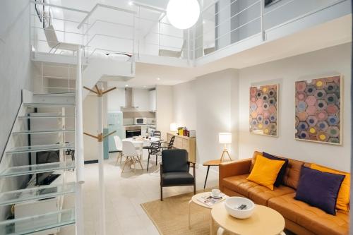 un soggiorno con divano e tavolo di HOMEABOUT RETIRO Apartment II a Madrid