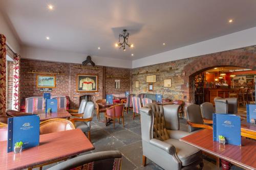 a restaurant with tables and chairs and a brick wall at Dooley's Hotel in Waterford