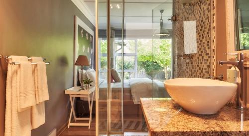 a bathroom with a large sink and a shower at Upper House Guesthouse in Clarens