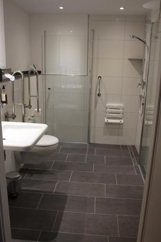 a bathroom with a sink and a shower and a toilet at Landhaus Jägerkrug in Paderborn