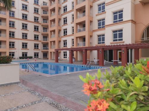 a swimming pool in front of a building at شقة مارينا البيلسان - عائلات فقط in King Abdullah Economic City