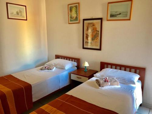 a bedroom with two beds and a table with a lamp at Trilocale Lalla sul mare in Gallipoli
