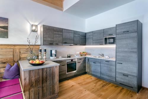 a kitchen with wooden cabinets and a bowl of fruit on a counter at Almdorf Almlust in Flachau
