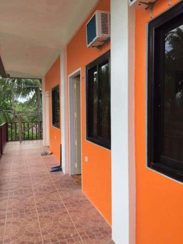 an empty hallway of a house with an orange wall at Lotus Sun & Waves Beach Resort in Baler