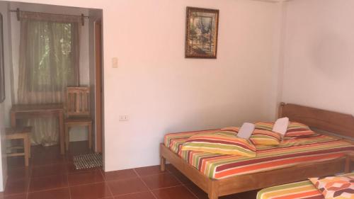a bedroom with a bed and a picture on the wall at Lotus Sun & Waves Beach Resort in Baler