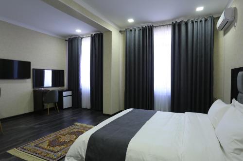 um quarto de hotel com uma cama e uma televisão em Hotel 777 em Dushanbe