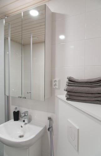 a white bathroom with a sink and a mirror at Lapland Arctic Apartments in Rovaniemi