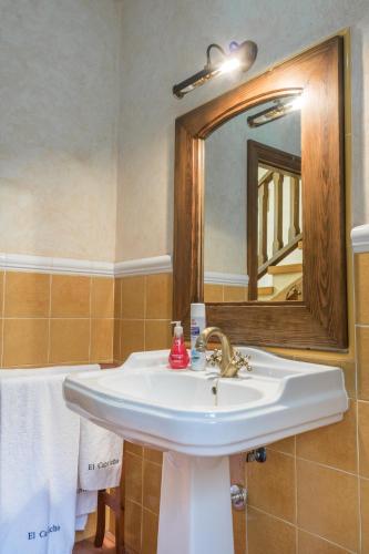 a bathroom with a white sink and a mirror at Casa Rural El Capricho in Otero de Herreros
