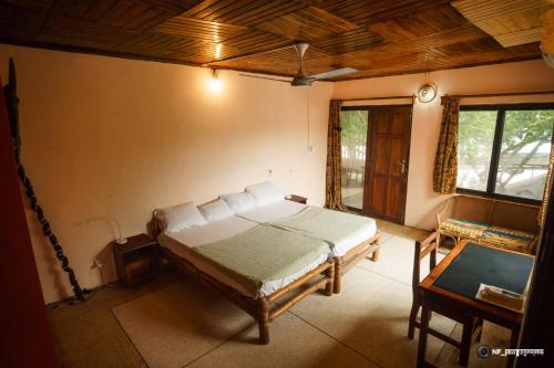 een slaapkamer met een bed in de hoek van een kamer bij Busua Inn in Busua