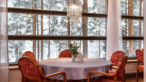 a dining room with a table and chairs in front of a window at Hotel Kajaani in Kajaani