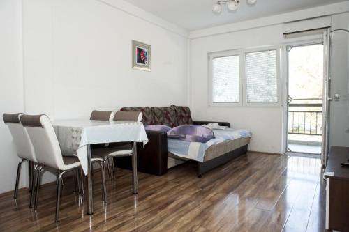 a living room with a bed and a table and chairs at Apartments Villa Zora in Star Dojran