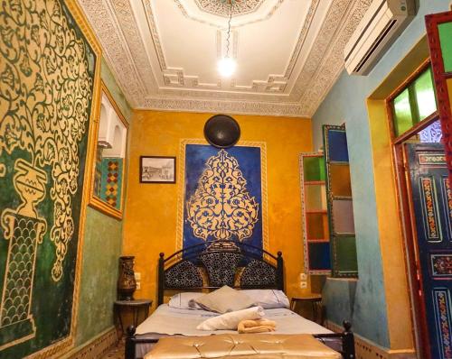 1 dormitorio con 1 cama y una pintura en la pared en Riad Jennah Rouge, en Marrakech