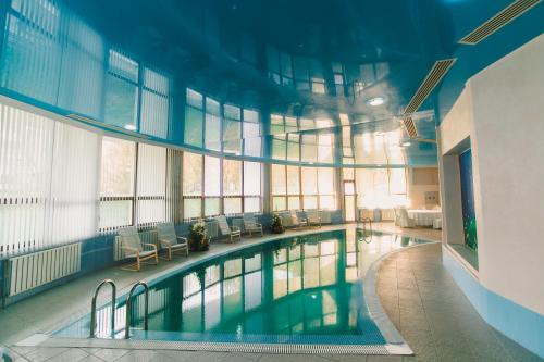 a large swimming pool in a large building with windows at Акку in Astana