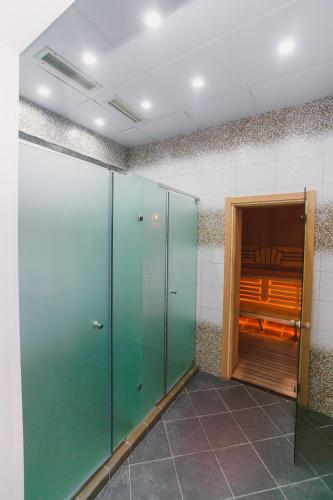 a hallway with green glass doors in a room at Акку in Astana