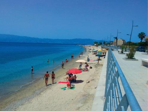 a group of people on a beach near the water at Villa La Fenice in Reggio Calabria
