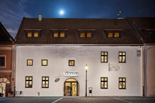 a white building with a doorway on the side of it at Boutique hotel & spa DOMA u nás - entry AquaCity free in Poprad