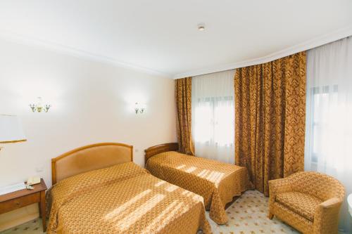 a hotel room with two beds and a chair at Акку in Astana
