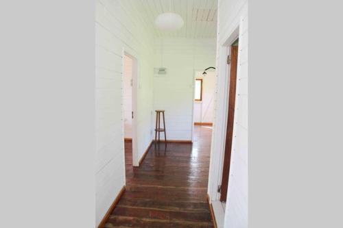 a hallway with white walls and a wooden floor at BEMA FARM in São José