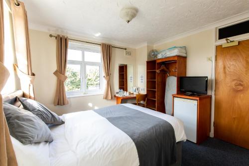 a hotel room with a bed and a television at Blue Boar Inn in Norwich