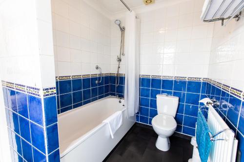 a bathroom with a toilet and a tub and a sink at Blue Boar Inn in Norwich