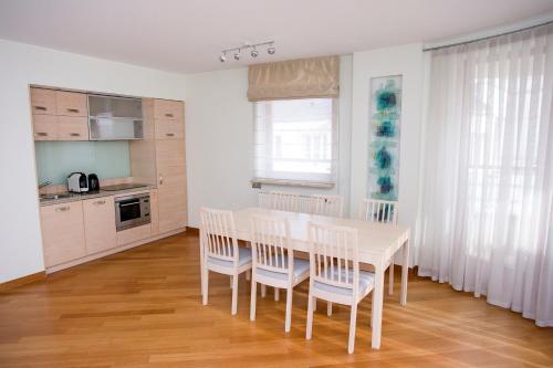 a kitchen with a white table and chairs in a room at Szucha Residence Apartments by Global Apart in Warsaw