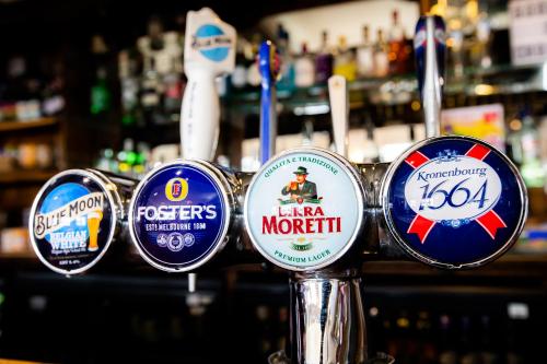 a bunch of bar signs on a counter in a bar at Blue Boar Inn in Norwich