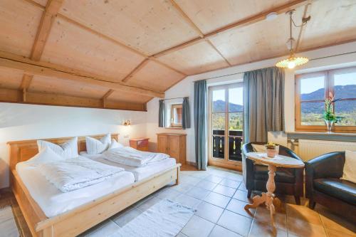 um quarto com uma cama, um sofá e uma mesa em Jaudenhof - Apartment Schönbergalm em Lenggries
