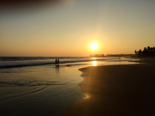 two people standing on the beach at sunset at Casa Vana Hiriketiya in Hiriketiya