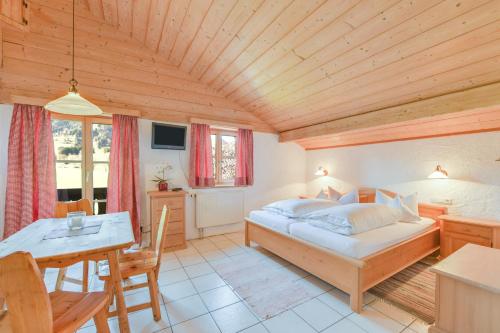 a bedroom with a bed and a table and a dining room at Jaudenhof - Apartment Kotalm in Lenggries