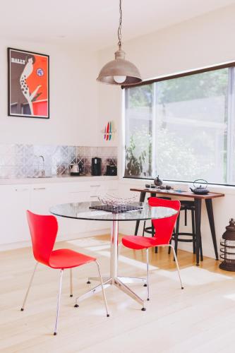 a dining room with red chairs and a glass table at Dalblair Bed & Breakfast in Seville
