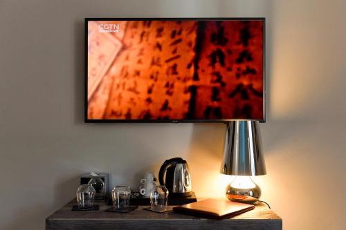 a table with a lamp and a painting on the wall at Du Parc Hotel in Sauze dʼOulx