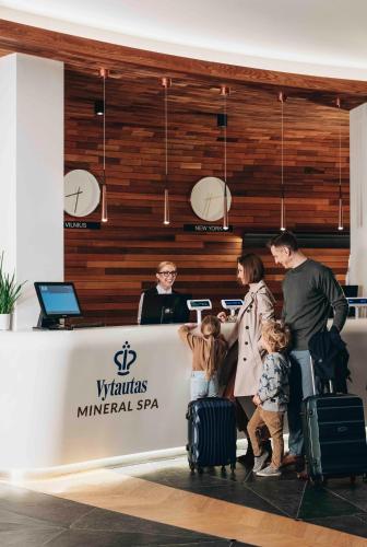 a group of people with luggage standing in front of a counter at Vytautas Mineral SPA in Birštonas