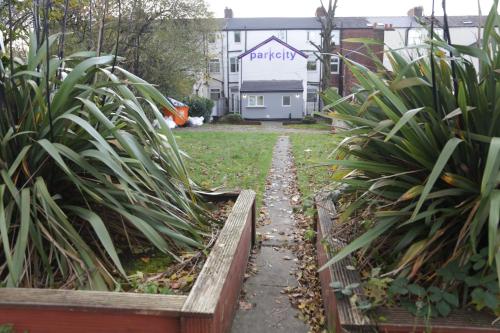 a path in a yard with plants and a house at Park City Rooms in Manchester