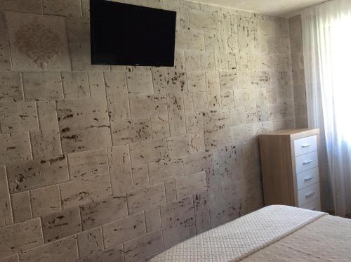 a bedroom with a stone wall with a tv on it at Apartamento Maracaibo in Astorga