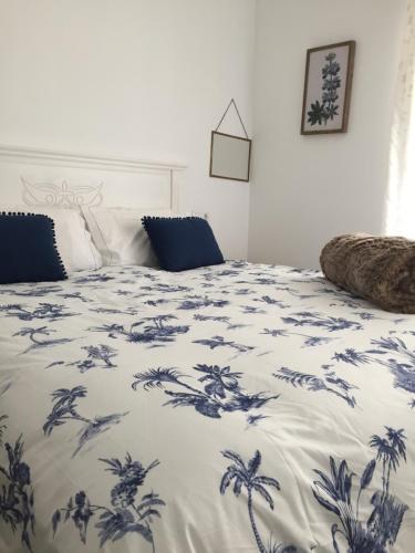 a bedroom with a bed with a blue and white blanket at El nido del Chorro in Málaga