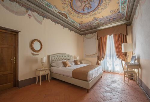 una camera con letto e soffitto a cassettoni di Relais Corte Rodeschi a Camaiore