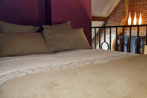 uma cama num quarto com uma parede de tijolos em B&B Casa Luna Loft em Dendermonde
