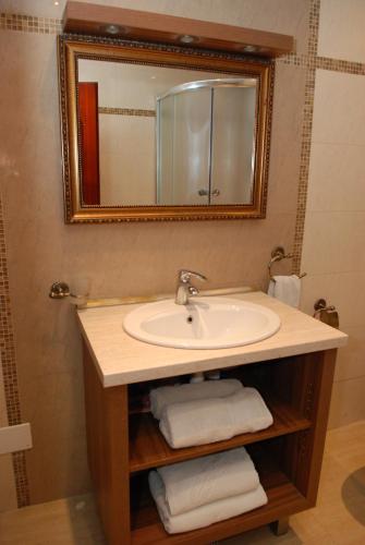 a bathroom with a sink and a mirror and towels at Guest House Maja in Novi Sad