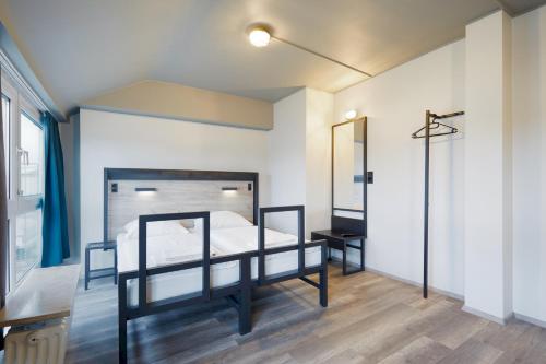a bedroom with a bed and a mirror at a&o Düsseldorf Hauptbahnhof in Düsseldorf