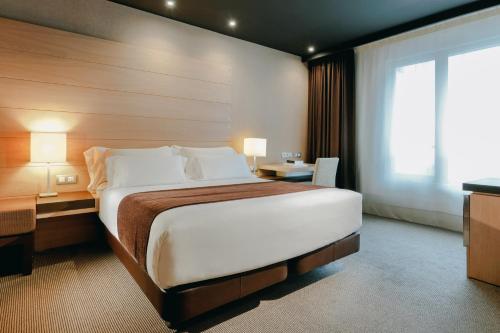 
a hotel room with a large bed and a large window at Hesperia Bilbao in Bilbao
