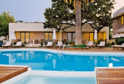 a swimming pool with chairs and a hotel at ABAV2 Suites by Rodos Palace in Ixia
