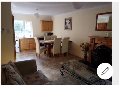 a living room and kitchen with a table and chairs at Mullaghbeag Lodge in Navan