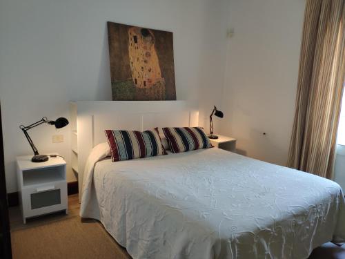 a bedroom with a bed with two lamps on it at La Chimenea Verde in Tacoronte