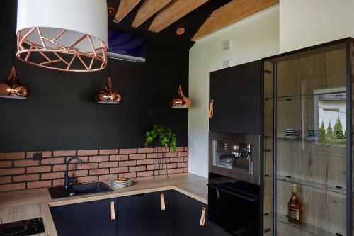 cocina con paredes negras y pared de ladrillo en Apartament Balance z prywatną sauną en Szczyrk