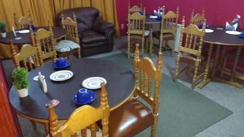 a dining room with a table and chairs and a table and chairs at Hostal El Toque de Pilar in Punta Arenas