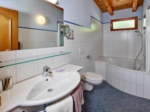 a bathroom with a sink and a tub and a toilet at Kristiania in Sölden